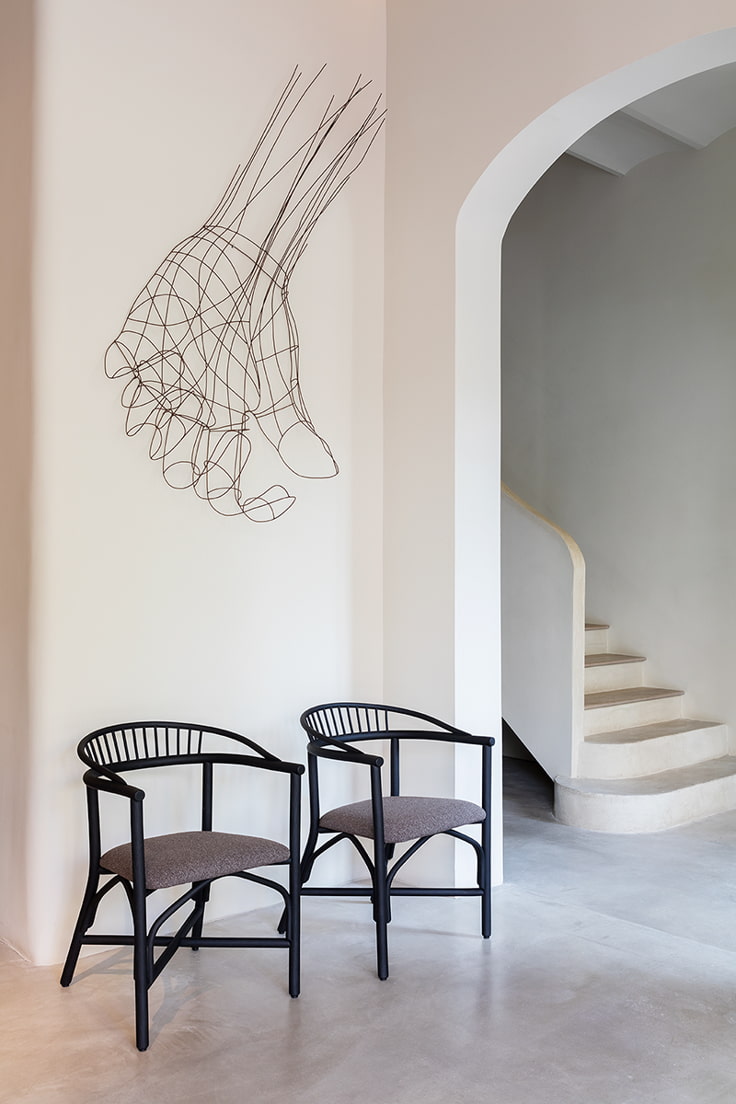 un par de sillas de expormim junto con elemento de diseño en la pared